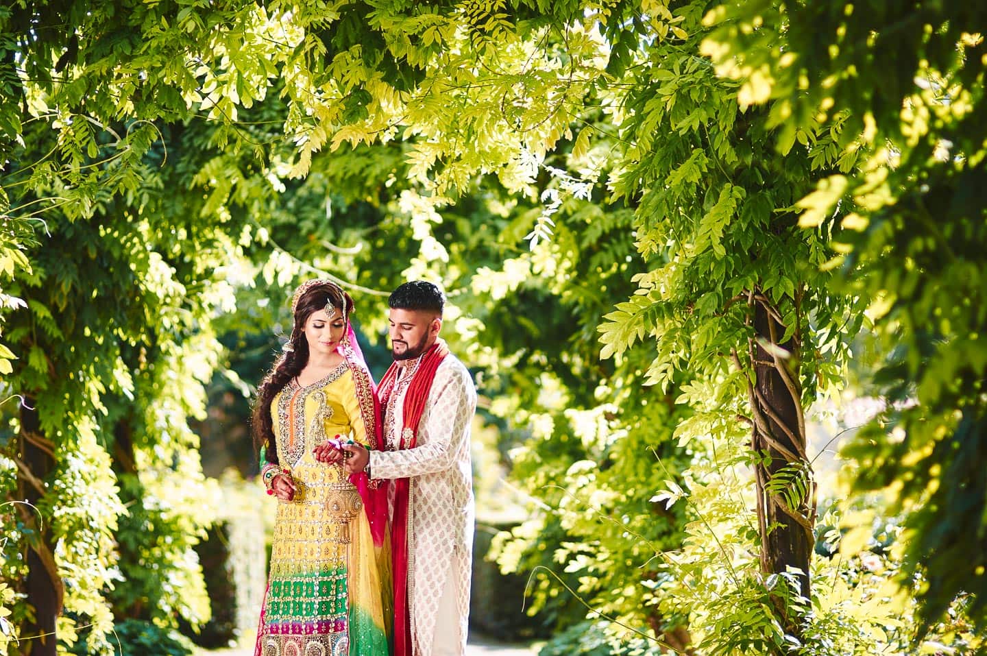 Bryllupsbillede af pakistansk par, i grønne omgivelser